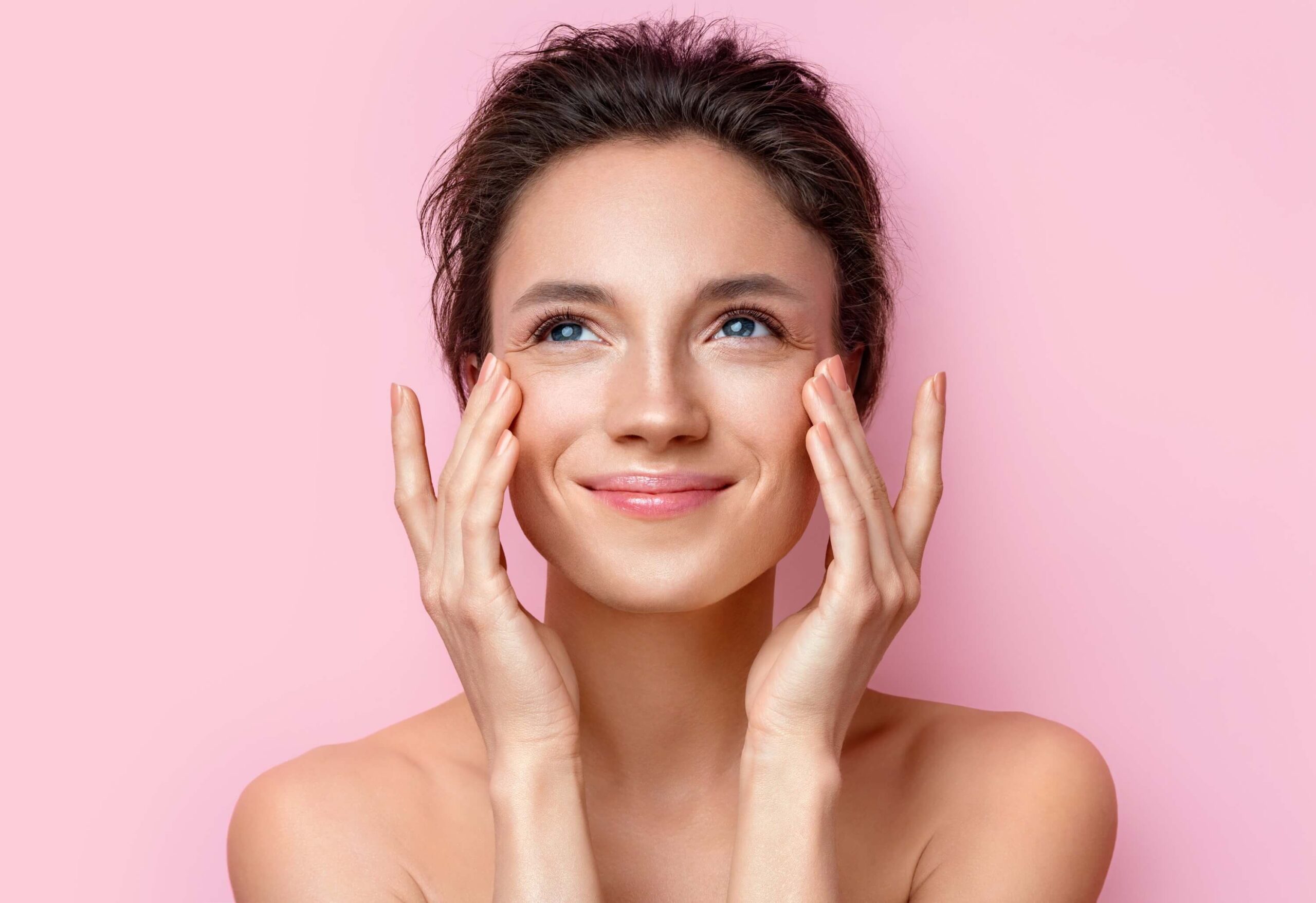 Beautiful woman with perfect skin on pink background